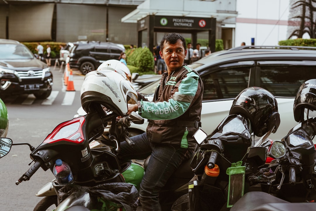 services-img-01 Grab Bike Driver picking up passenger. Grab is a technology company that offers wide range of ride-hailing and logistics services through its app in Southeast